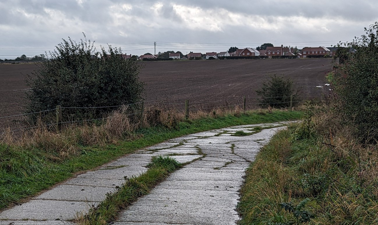 Modern settlement edge of Drayton seen across large open arable fields